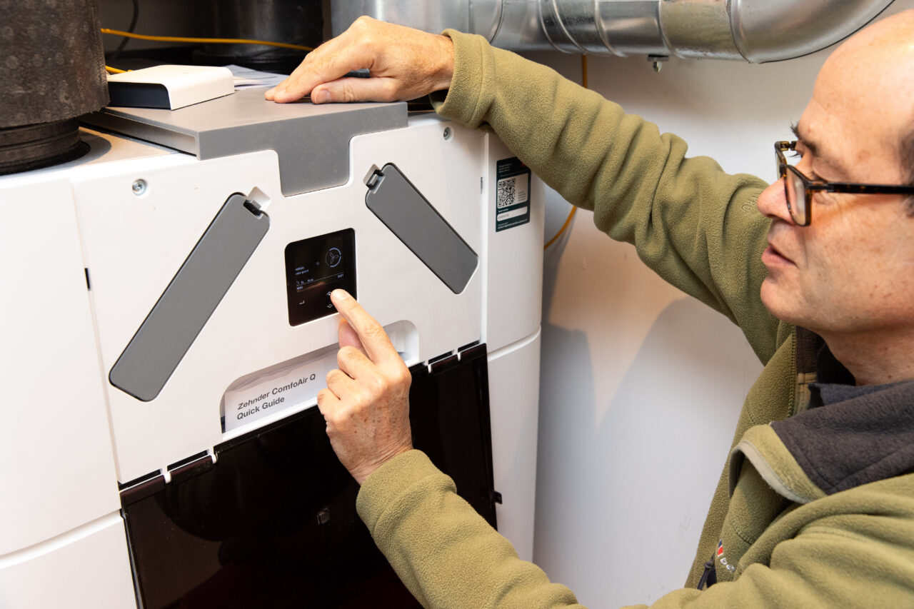 man using the user panel on the external face of the mechanical ventilation unit.