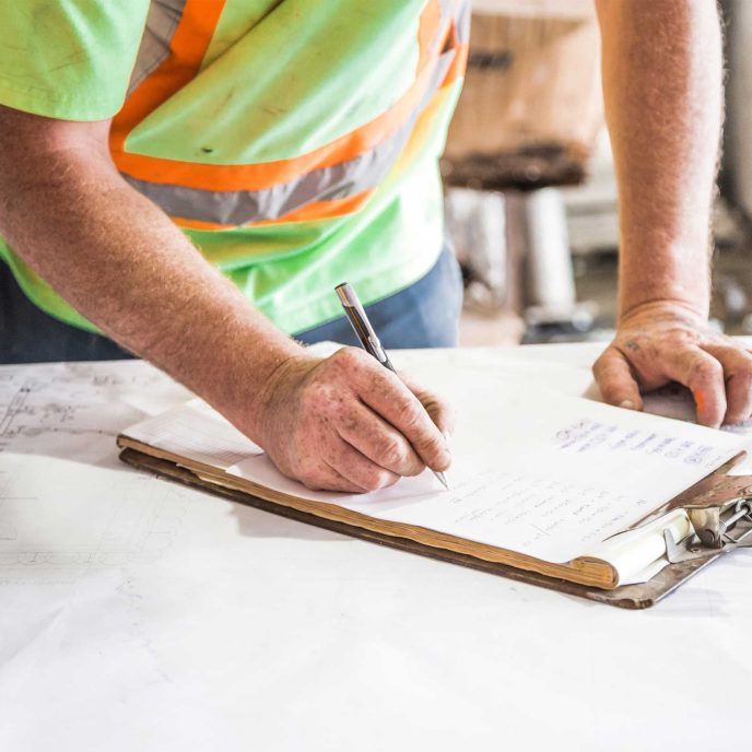 Builder making notes on a clipboard - Retrofit West