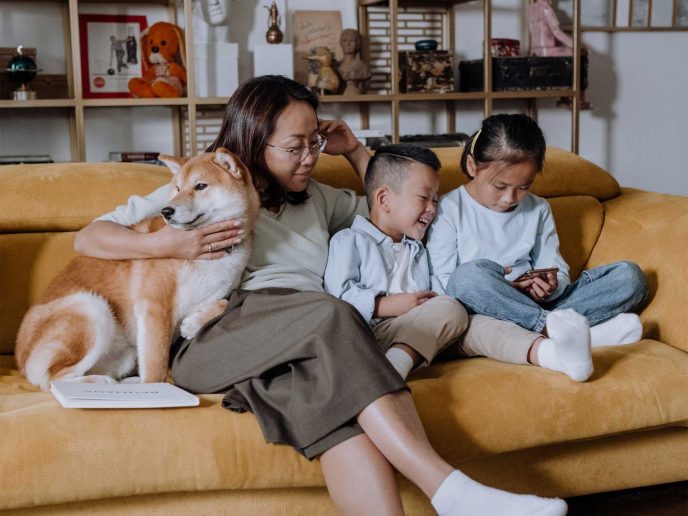 Mum and two children sitting with their Shiba Inu on the sofa - Retrofit West
