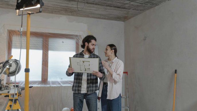 A couple looking at the floorplan of their home during renovation - Retrofit West