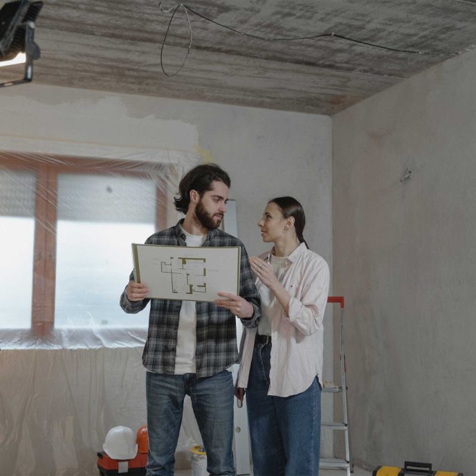 A couple looking at the floorplan of their home during renovation - Retrofit West
