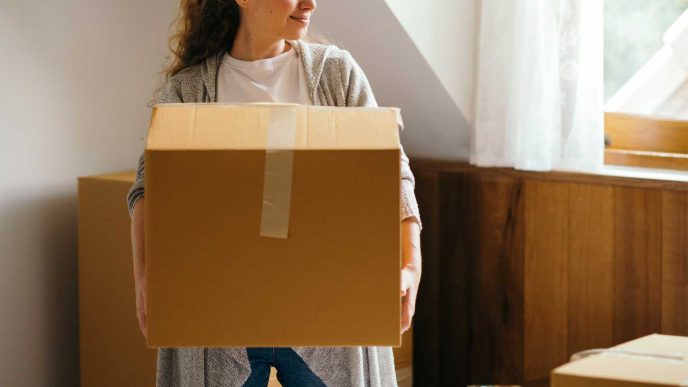 A new home owner unpacking boxes in her new house - Retrofit West