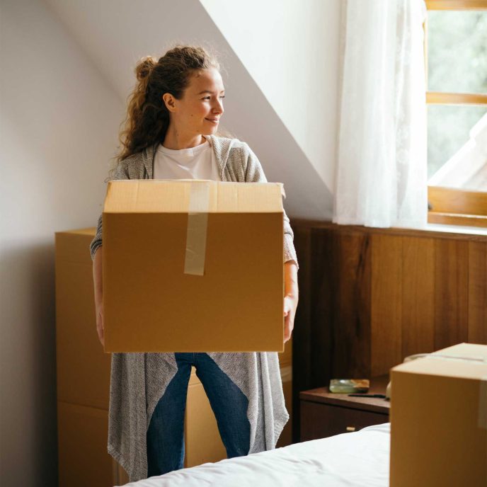 A new home owner unpacking boxes in her new house - Retrofit West