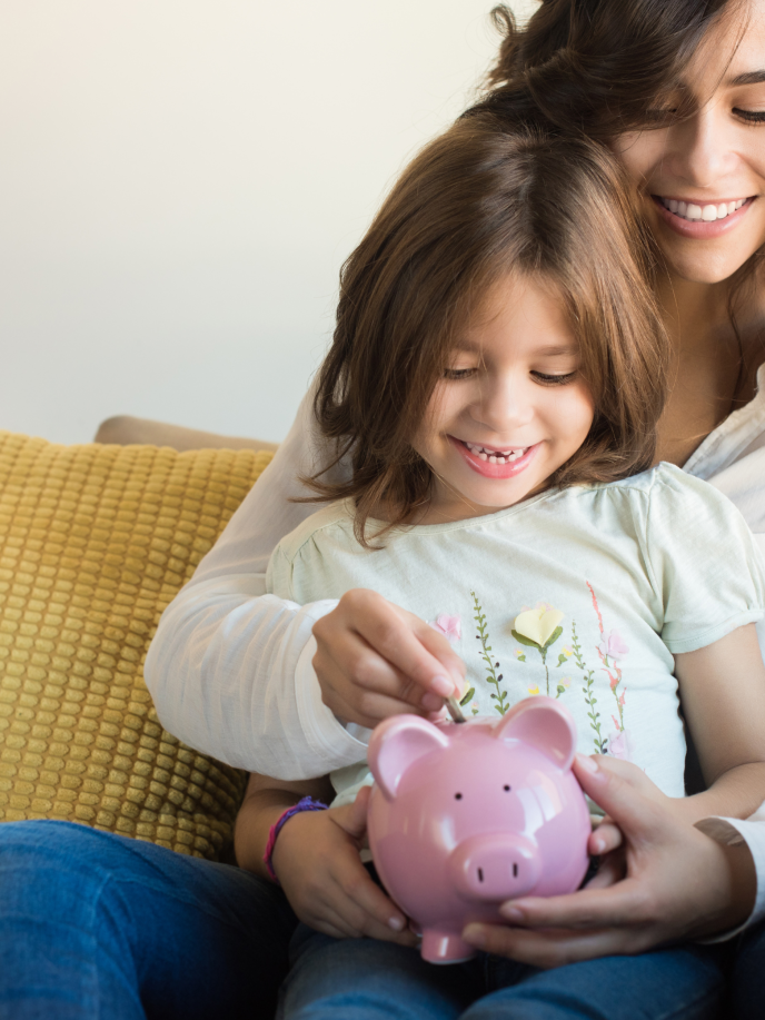 Mum and daughter adding money into a piggy bank - Retrofit West
