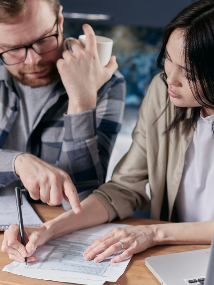 Two people going through a document with a calculator and note pad - Retrofit West (3)
