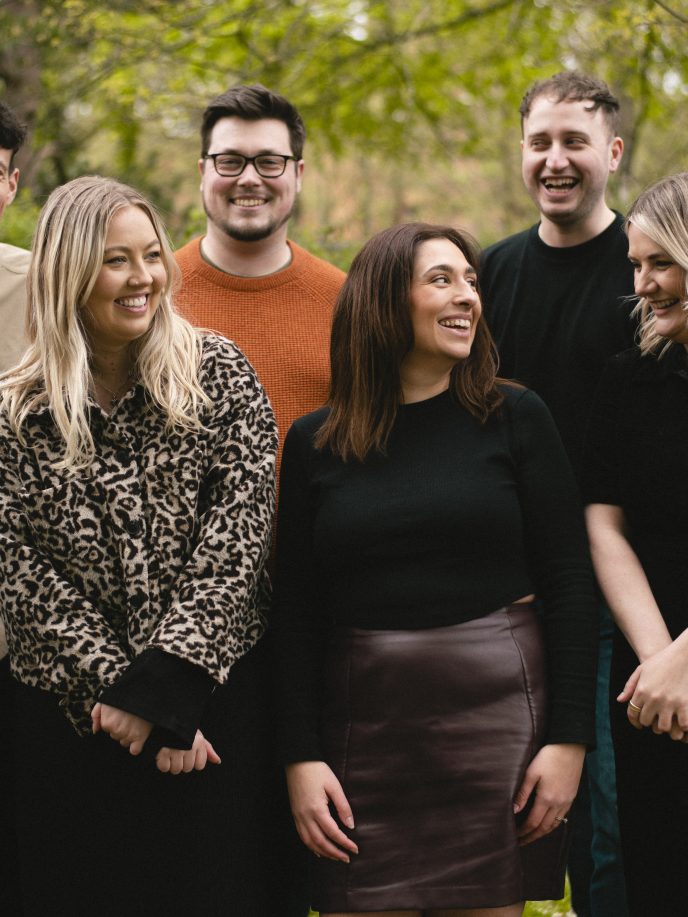Group of people stood in the park, laughing with each other