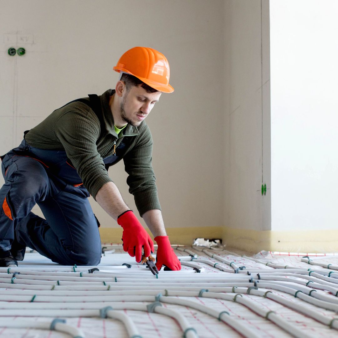 technician fitting underfloor heating pipes