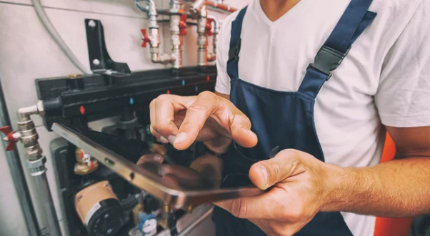 technician touching the control panel for a heat pump system