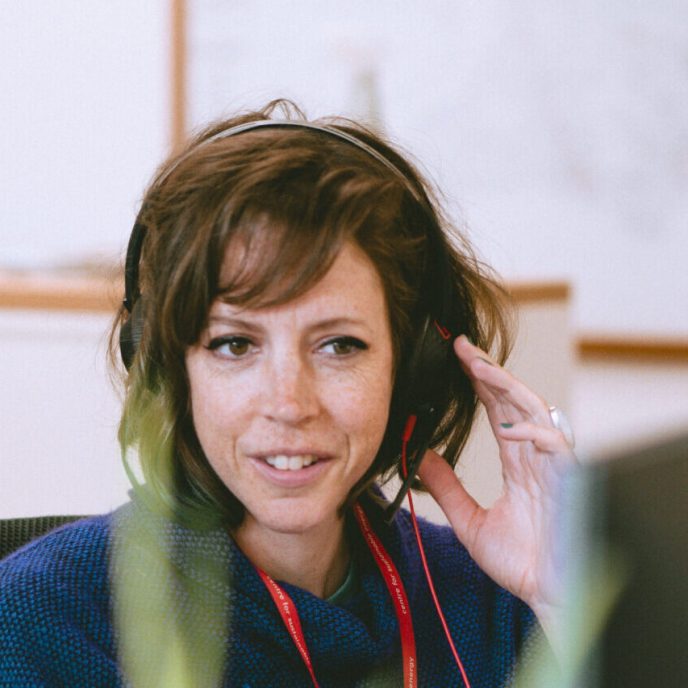 Woman at desk with headset on for a phonecall - Retrofit West