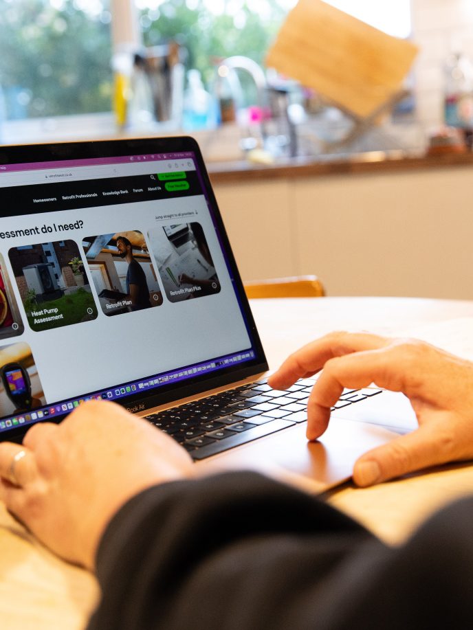 Using the Retrofit West website at home in Bristol to look up energy efficiency assessments. November 2024.