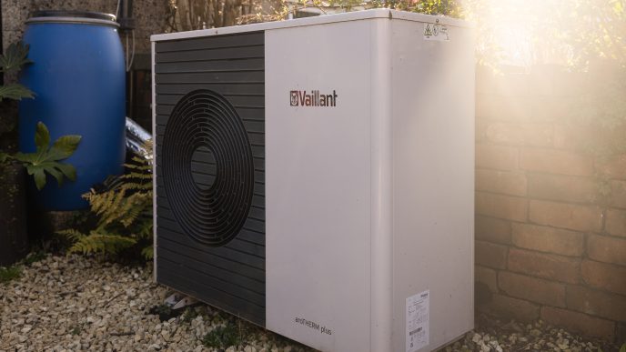 Heat pump unit in a back garden, placed on gravel