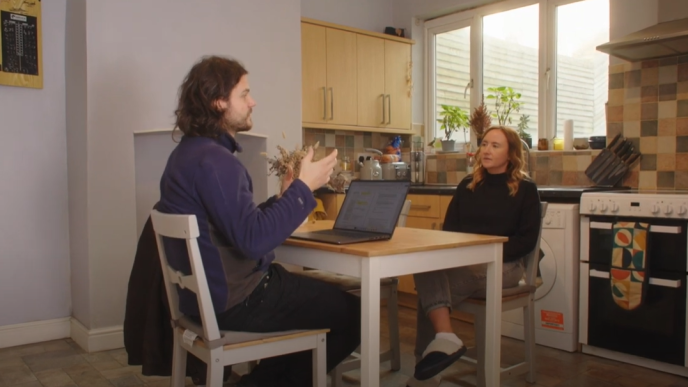 advisor stills at a kitchen table chatting to a homeowner