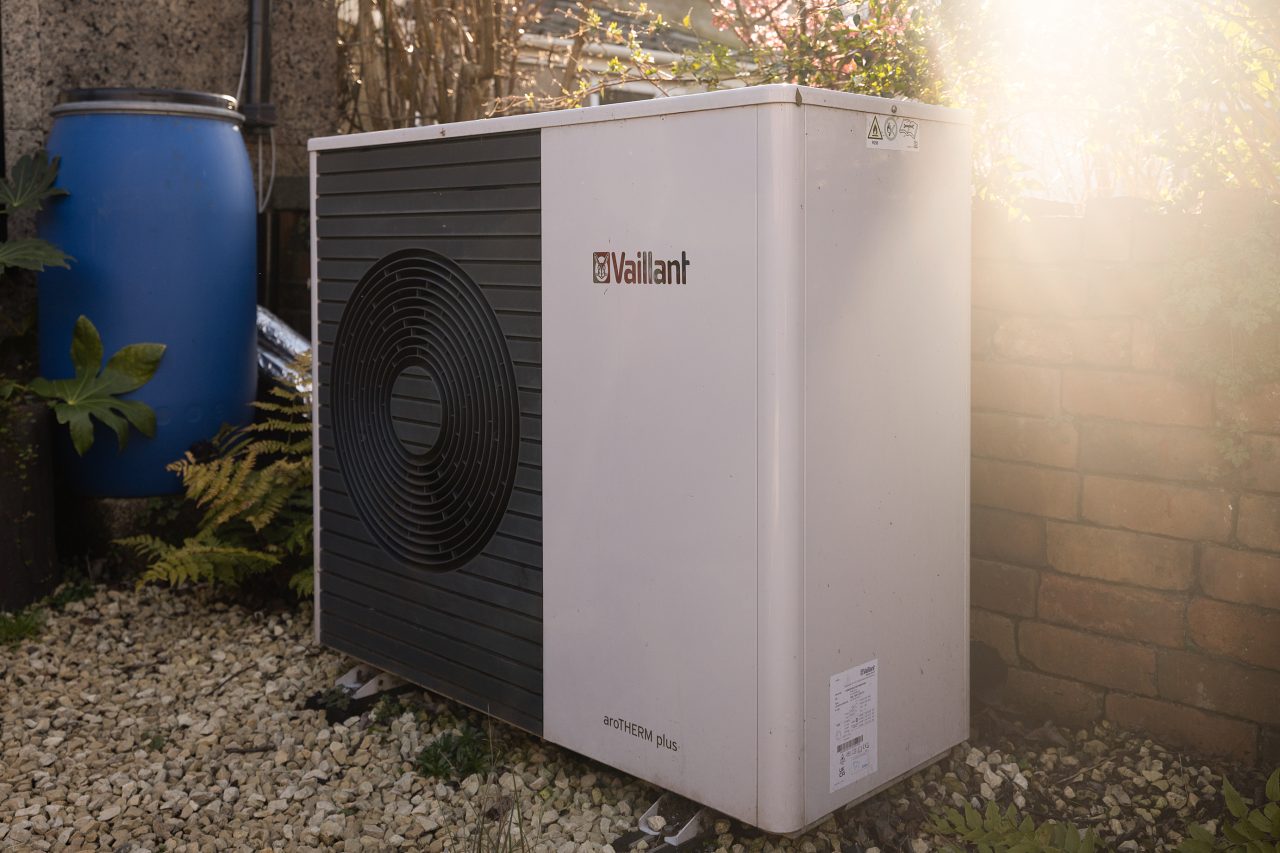 Heat pump unit in a back garden, placed on gravel