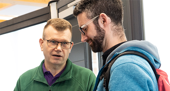 energy advisor from Retrofit West, talking to a young man in a blue jacket.