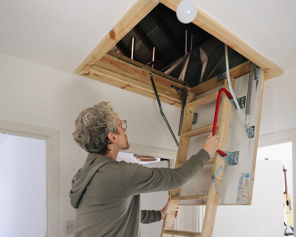 kirk climbing the ladder to enter the loft inside his home