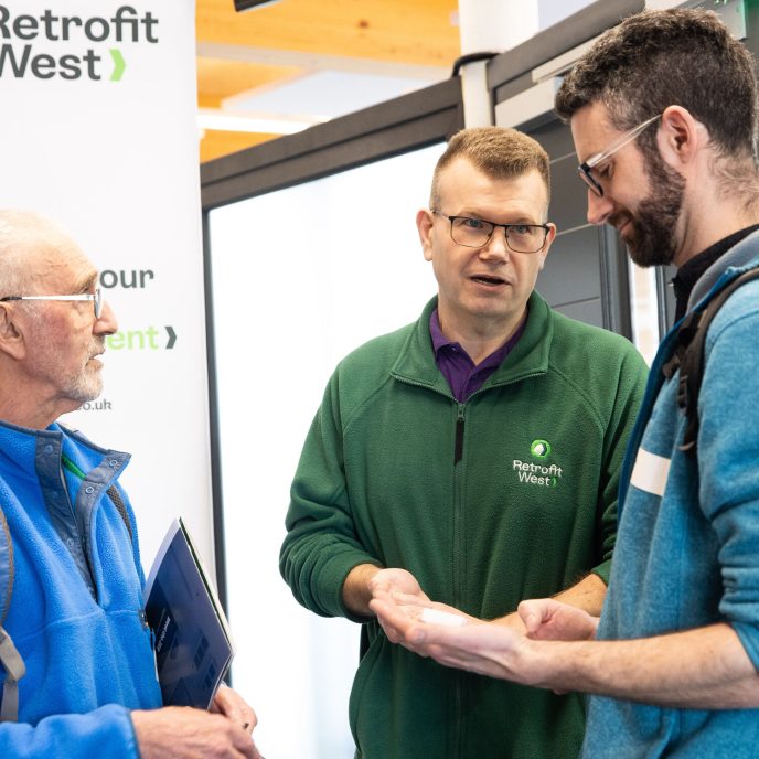 Retrofit West advisor talking to two homeowners at the Home Energy Fair in Bath