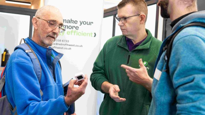 2 members of the public speaking to Retrofit West Consultant Matt at the Home energy Fair in Bristol.