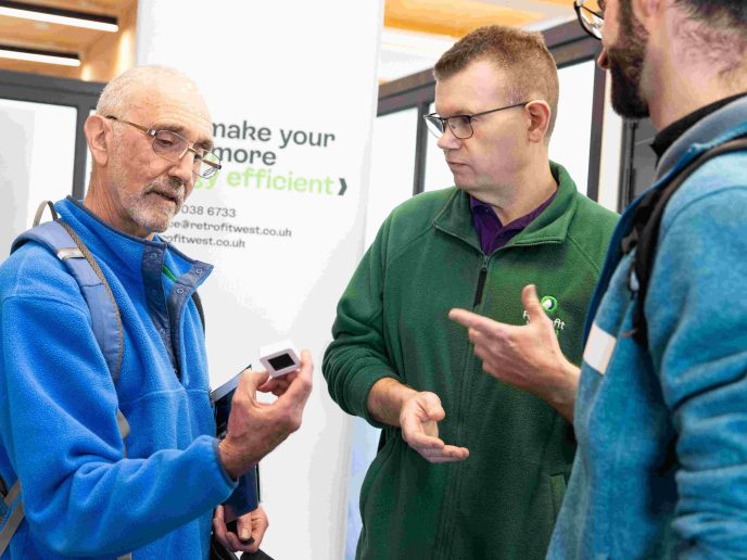 2 members of the public speaking to Retrofit West Consultant Matt at the Home energy Fair in Bristol.