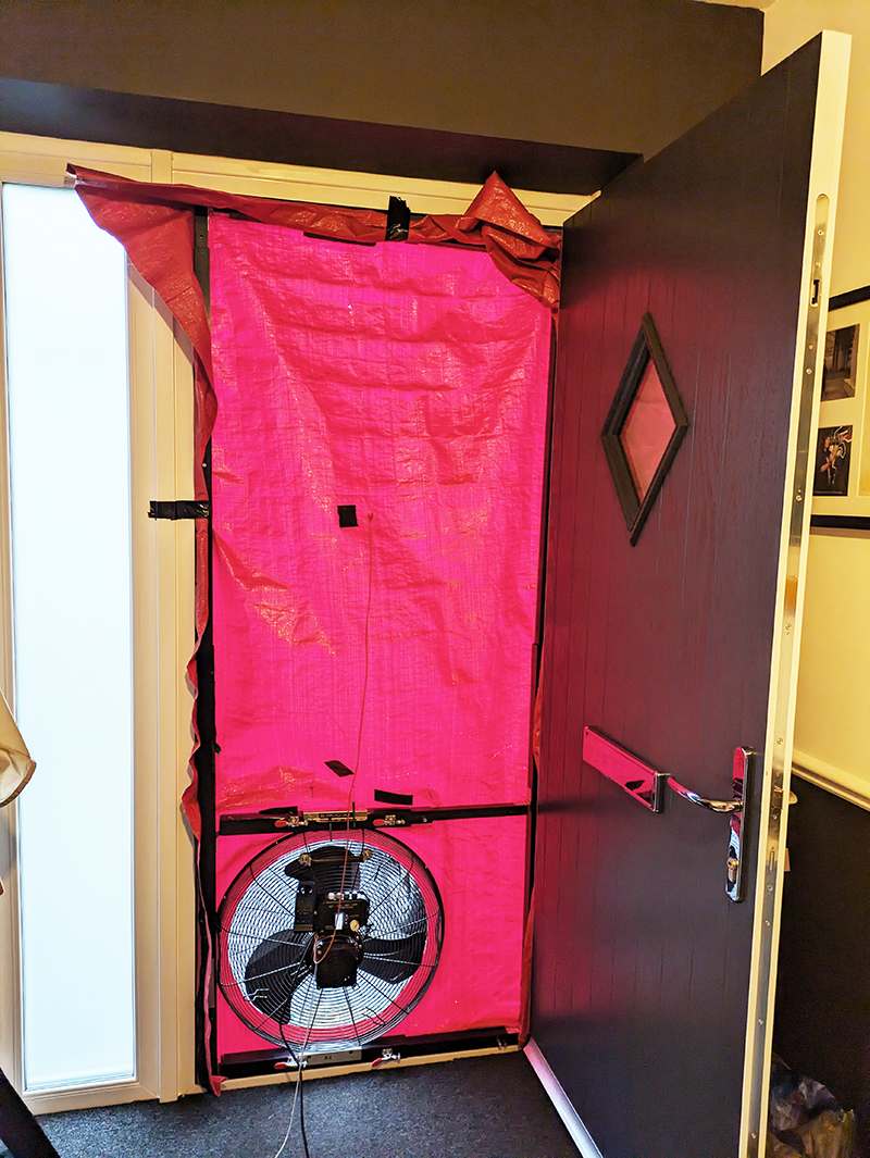 red canvas on open front door with black fan at the bottom